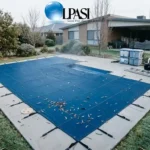Winter pool maintenance tips: covered Australian backyard pool with mesh safety cover, leaves cleared, and equipment pad in winte